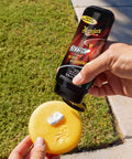 Person applying Scratch-X Car Scratch Remover For Fine Scratches And Blemishes Quick Fix on a foam pad outdoors
