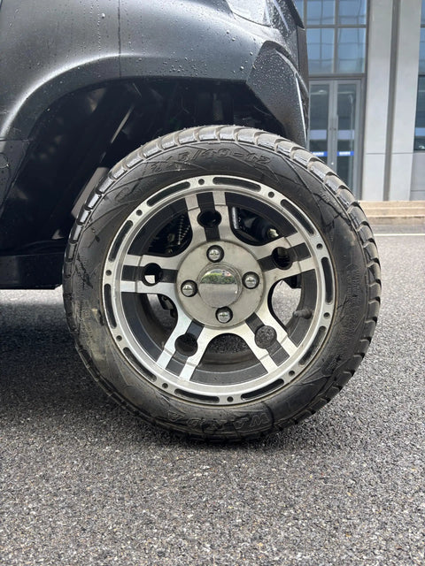 Close-up of the alloy wheel and tire of Bad Boy Six Seater Golf Cart And Sightseeing Patrol Wagon With Slick 4Kw Electric Motor And Zero Hassle 48V Lithium Battery Pack For Smooth Resort Cruising Or Tight Site Security Jobs All Week.