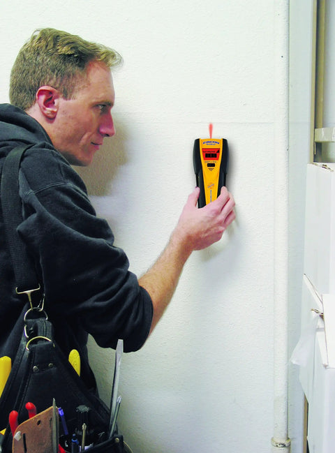 Slick All In One Stud Finder Pins Wood Metal And Live Ac Wires Fast With A Bright Lcd Screen and Pinpoint Focus being used on a wall.
