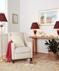 Three Lamp Set With Burgundy Ceramic And Brass Table And Floor Lamps, Includes One Floor Lamp And Two Table Lamps in a living room setting