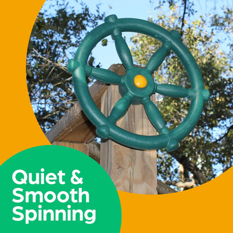 Green Pirate Ship Wheel Outdoor Playset Accessory For Kiddos on a wooden mount, treehouse in the background, safe for play.
