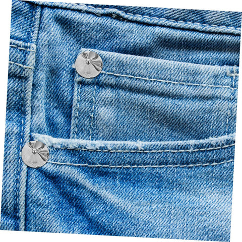 Front view of blue denim pocket with silver round rivet studs