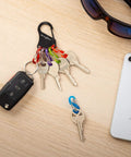 Key Rack Steel S Biner Carabiner Organizer With Six Colorful S Biners For Keys Securely And Separately on table with phone
