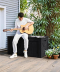 Man playing guitar sitting on 120 Gallon Outdoor Deck Box Heavy Duty Resin Construction Weatherproof Lockable Storage