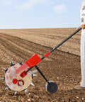 Person using Walk Behind Hand Push Seeder With 10 Equidistant Nozzles For Precise Quantitative Sowing on tilled soil