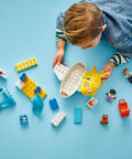 Child playing with First Airport Playset For Toddlers And Preschoolers With Airplane And Airship pieces on a blue surface