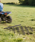 Heavy Duty ATV Chain Drag Harrow 4 Foot Wide By 4 Foot Long With One Half Inch Tines in use on grass field, attached to ATV