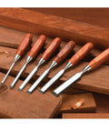 Tough As Nails Six Piece Bench Chisel Set Premium Hardened Steel Blades Genuine Bubinga Handles laid on wooden surface.