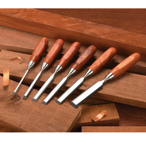 Tough As Nails Six Piece Bench Chisel Set Premium Hardened Steel Blades Genuine Bubinga Handles laid on wooden surface.