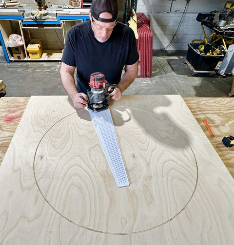 Man using Circle Cutter Router Jig for precise circle cuts from seven to fifty two and three quarters inches on plywood.