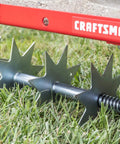 Close-up of 36-Inch Tow-Behind Spike Aerator for Lawns with 9 galvanized disks and 80 lb weight tray, red rugged frame.