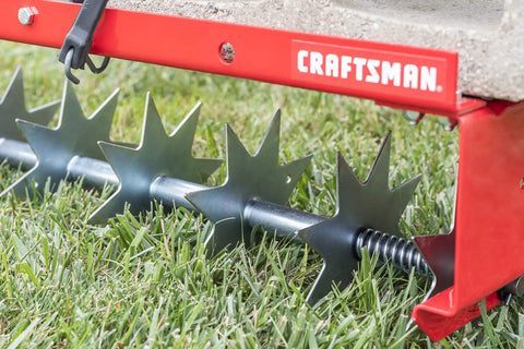 Close-up of 36-Inch Tow-Behind Spike Aerator for Lawns with 9 galvanized disks and 80 lb weight tray, red rugged frame.