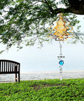Three Pack Gazing Ball Spiral Tail Wind Spinner Set With Hanging Swivel Hooks For Indoor Outdoor Decor Glass Orbs In Red Sky Blue And Navy Blue For A Killer Garden Balcony Vibe. Hanging gold tree wind spinner with blue glass orb in garden