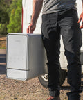 Person holding a portable straight plug countertop dishwasher, perfect for tiny kitchens or campers, with touch interface.