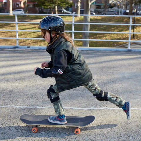 Child wearing Dry Erase Kids Helmet For Bike, Skate, Scooter And Inline Skating With Neon Markers And Stencil Kit skateboarding outdoors.