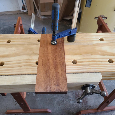 Quick-Adjust Vertical Workbench Hold Down Clamp For Three Quarter Inch Dog Holes, No-Slip Grip, One And A Half Inch Post With Serrations Keeps Thick Workpieces Up To Seven Inches Secure, Cast Zinc Durable Holdfast securing wood piece on bench