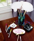 Crafting table with supplies including markers and camera, possibly using White Dry Erase Tape 1.88 Inch Wide By 5 Yard Length 6 Pack