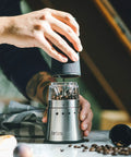 Portable Electric Coffee Grinder With Stainless Steel Burrs And Nine Precision Settings For Espresso To French Press Compact design in use.