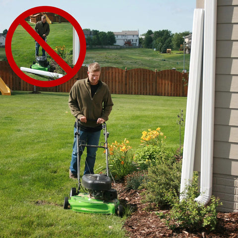 Man mowing lawn with Flip Up Downspout Hinge Kit For Easy Yard Access No Detach Needed Perfect For Lawn Mowing Fits 2x3 And 3x4 Downspouts And 5In Or 6In Gutters DIY Install 6 Pack Made In USA.