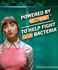 Woman in pink dress stands beside text promoting Fresh Breath Mouthwash With OXYD8 And Zinc Gluconate To Knock Out Bad Breath, 16 Fl Oz Pack Of 2.