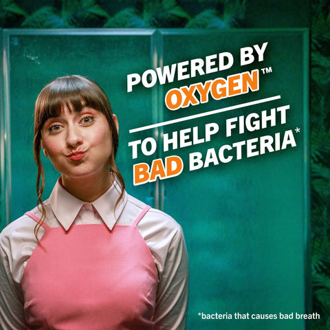Woman in pink dress stands beside text promoting Fresh Breath Mouthwash With OXYD8 And Zinc Gluconate To Knock Out Bad Breath, 16 Fl Oz Pack Of 2.