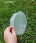 Holding one of the Two Pack Plastic Round Bird Feeder Bowls For Wild Birds Seed Tray And Water Bowl At Feeding Stations