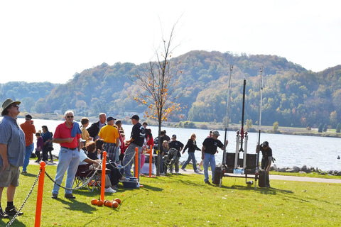 People gathered outdoors with Safety Orange Plastic Barrier Chain, 2-Inch Link, 100-Foot Length for Crowd Control visible at park.