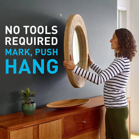 Heavy Duty Drywall Picture Hangers Six Pack Holds Up To 15 Lbs Each With No Studs Required For Hassle Free Room Refresh And Office Display Featuring Sturdy Steel Build For Bold Wall Art with woman hanging mirror.