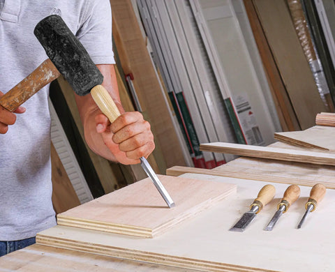 User striking wood with a mallet using the Built Tough 4 Piece Bench Chisel Set For Serious Woodworkers Carved From Top Shelf Chrome Vanadium Steel Blades That Serve Up Knockout Clean Cuts And Hold An Ice Cold Sharpness All Day Long.