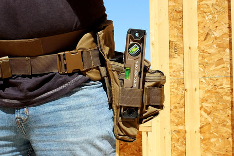 Magnetic Box Beam Level For Framing And Layout 10 Inch Torpedo with Tourniquet Bungee in tool belt against wooden frame.