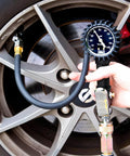 JACO FlowPro Tire Inflator with Pressure Gauge installed on car tire valve; black hose and blue dial gauge