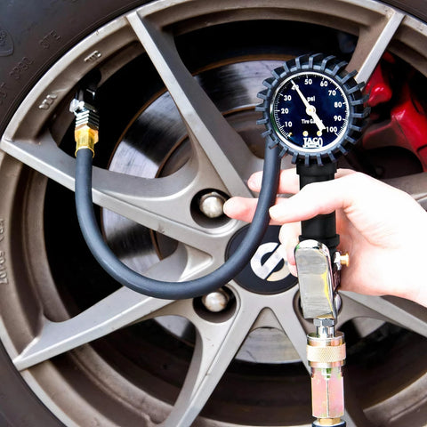 JACO FlowPro Tire Inflator with Pressure Gauge installed on car tire valve; black hose and blue dial gauge