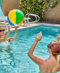 Two women playing with a large colorful beach ball in a pool, enjoying a summer day with 4 Pack 20 Inch Rainbow Beach Balls Large Inflatable Pool Toys For Parties Decorations For Adults And Kids Luau Summer Beach Water Games Beach Ball Favors