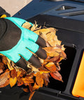 Hand adding leaves to 43 Gallon Dual Chamber Tumbling Compost Bin With Sliding Doors, Rotating Batch Composter For Garden And Kitchen Scraps