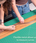 Heavy Duty Stainless Steel Ruler 24 Inch With Cork Backing, being used to measure curvature on a crafting table.