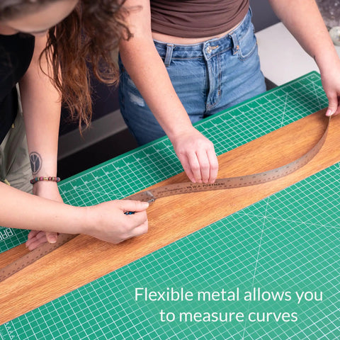 Heavy Duty Stainless Steel Ruler 24 Inch With Cork Backing, being used to measure curvature on a crafting table.