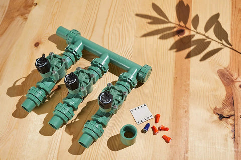 Heavy Duty 3 Valve Preassembled Irrigation Manifold with Swivel Unions shown with connectors on wooden surface