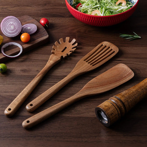 Three Piece Acacia Wood Spatula Set For Cooking, Teethed Pasta Spoon And Spaghetti Fork on wooden surface with salad