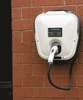Badass Level 2 EV Charger Hard Wired With 30 Amp 240 Volt J1772 Compatibility mounted on brick wall with a charging cable.