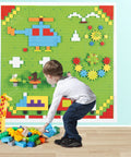 Child playing with Game Changing 812 Piece Building Blocks Kit Featuring Self Adhesive Wall Baseplates And Interconnected Marble Run Tracks.