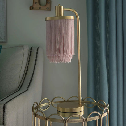 Framboise Fringe Shade Table Lamp With Gold Leaf Finish on a round side table in a living room setting