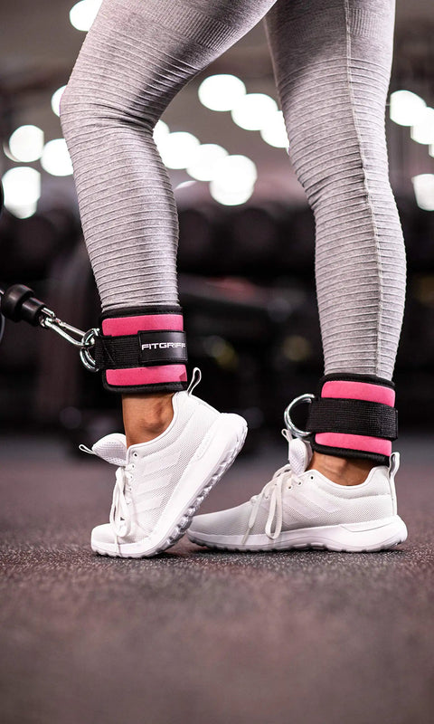 Heavy Duty Ankle Straps For Cable Machine Dual Pack Gym Workout Gear Designed For Serious Leg Development And Knockout Glute Activations Clutch Pulley Harness In Pink attached to ankles in gym.