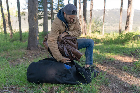 Person setting up Rip Stop Tarp 8 By 10 Feet Heavy Duty Waterproof Brown Outdoor Shelter For Camping And Backyard Use in forest.