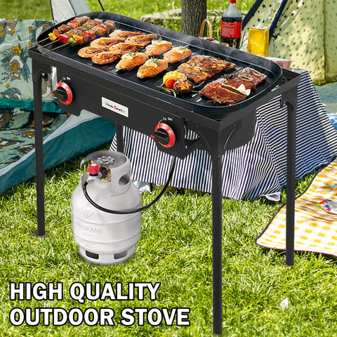 High Pressure Propane Outdoor Cooking Grill Burner For Camping And Backyard BBQs With CSA Regulator 0 To 20 PSIG And 4 Ft Gas Hose Dual Cast Iron Burners in use at outdoor event with food grilling.