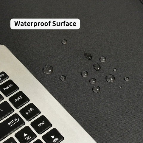 Beastly Gaming Mouse Pad 36 By 17 Inches Waterproof Non Slip Desk Keyboard Mat with water droplets on surface near laptop keyboard.