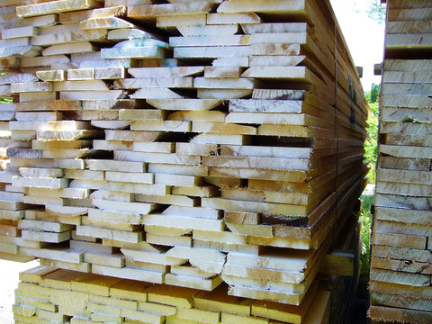 Stack of lumber using Classic Log And Lumber End Sealer Wax Emulsion Water Based Sealant That Keeps End Checks At Bay And Prevents Drying Splits