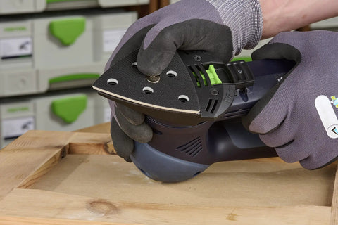 StickFix Hard Sanding Pad For DX 93 System in use, triangular pad with equal angle corners and convex edges on wood surface