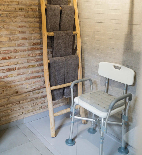 Heavy Duty Shower Chair With Arms And Back For Inside Showers, featuring non slip feet and waterproof seat next to a towel rack.