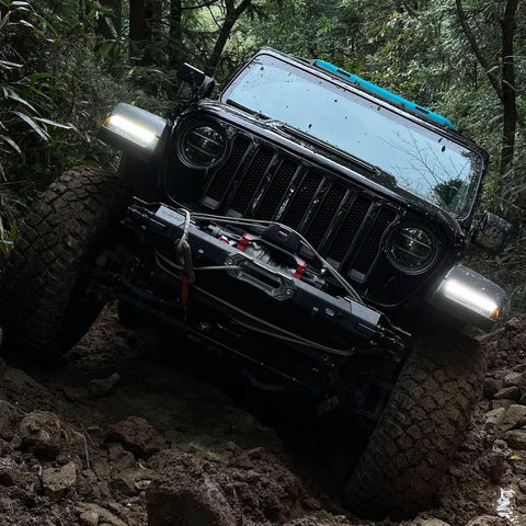 Jeep on rough terrain using Beefed Up Heavy Duty 13500 Pound Electric Winch For Off Road Recovery with 12V DC Power Wireless Remote