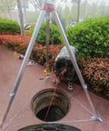Heavy Duty Confined Space Tripod With Rescue Winch And Fully Adjustable Retractable Legs For Wells And Sewers Commercial Extraction Hoist in use above a manhole.